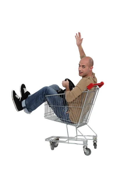 Bald man sat in trolley with steering wheel — Stock Photo, Image