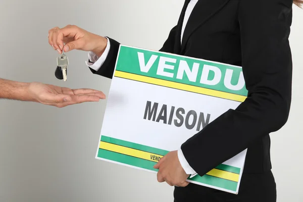 Immobilienmakler mit verkauftem Schild und Schlüsselübergabe an Kunden — Stockfoto