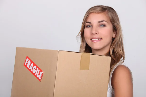 年轻女子与一个纸箱标记脆弱 — 图库照片