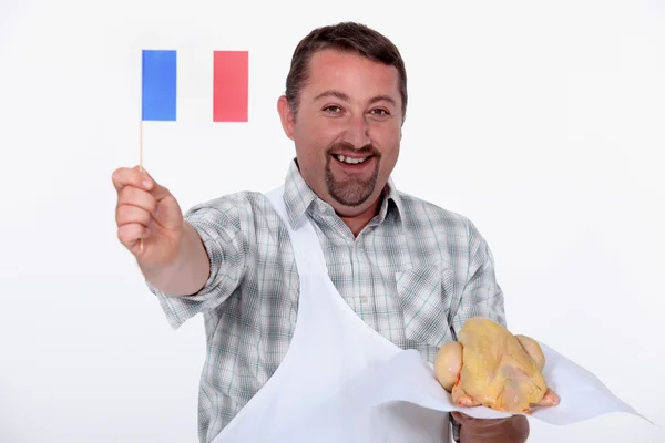 Franzose schwenkt stolz die Fahne über sein rohes französisches Huhn — Stockfoto