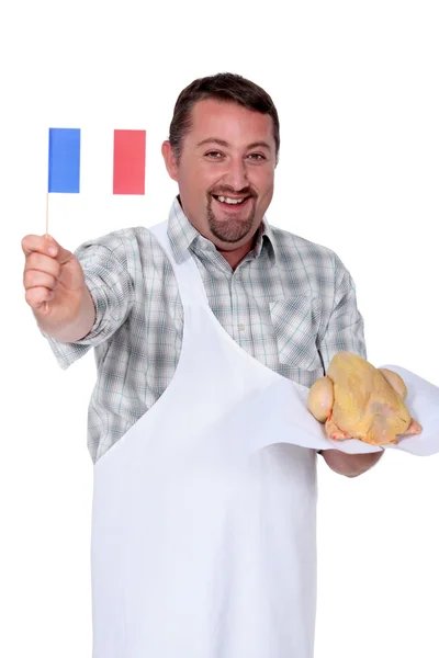 该名男子手持法国国旗和新鲜鸡 — 图库照片