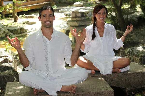 Paar meditiert im Garten — Stockfoto