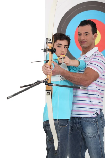 Мальчик с тренером по стрельбе — стоковое фото