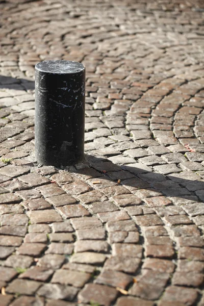 Post on a cobblestone street — Stock Photo, Image