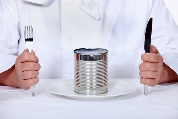 Chef sitting down to a tin can meal — Stock Photo, Image