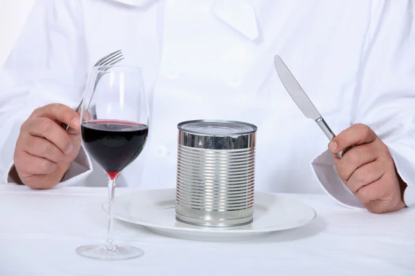 Chef sitting down to a canned dinner — Stock Photo, Image
