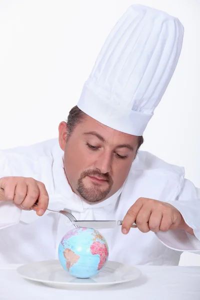 Шеф-кухар їсть земну кулю — стокове фото