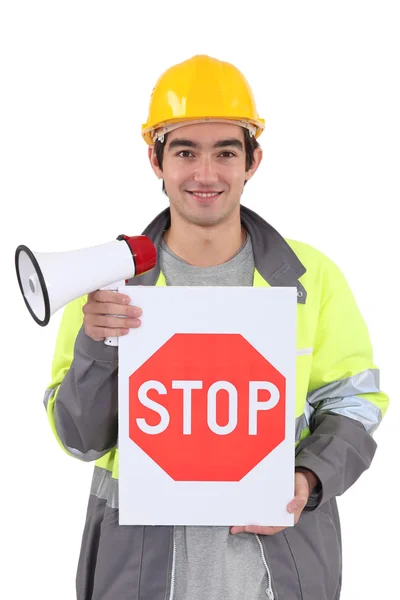 Tradesman holding a stop sign and a megaphone — Stock Photo, Image