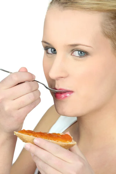 Vrouw eten brood en jam — Stockfoto