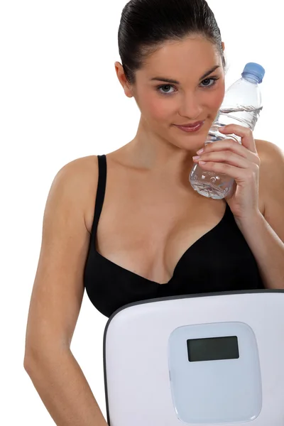 Mladá žena přenášení váhy a láhev vody — Stock fotografie