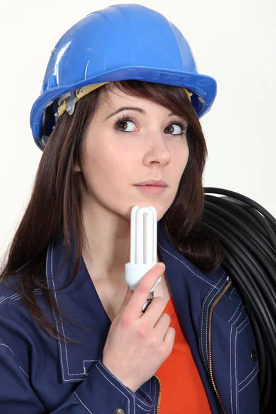 Thoughtful woman holding a compact fluorescent lamp — Stock Photo, Image