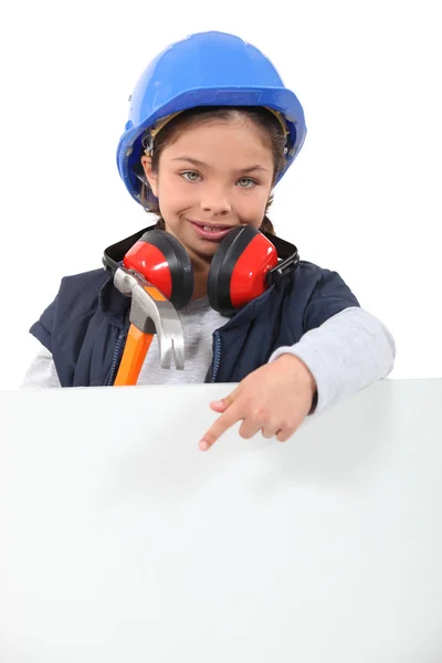 Criança vestida como um trabalhador da construção civil com uma placa deixada em branco para sua mensagem — Fotografia de Stock