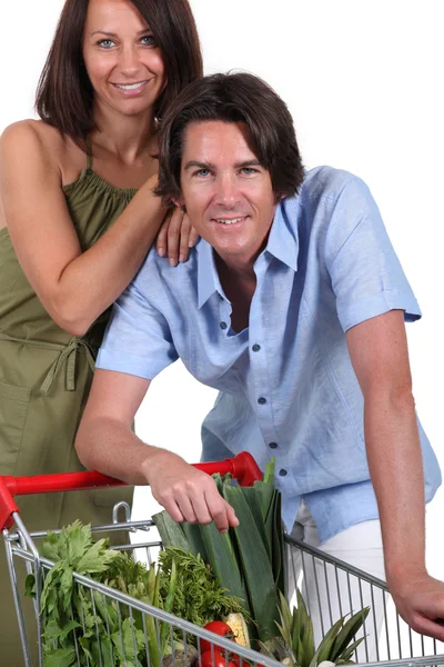 Paar mit Einkaufswagen voller Gemüse — Stockfoto
