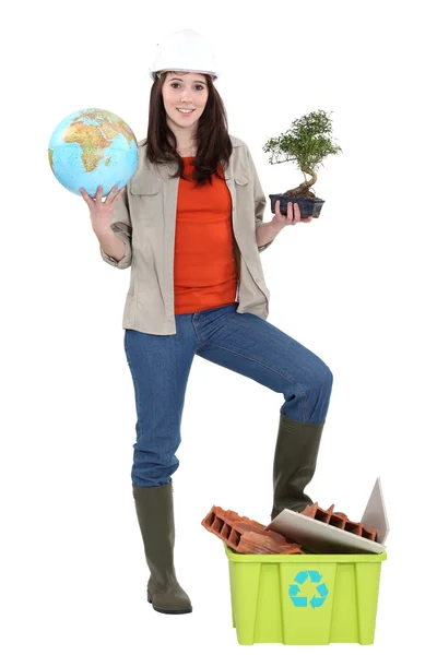 Construtora feminina segurando globo e planta — Fotografia de Stock