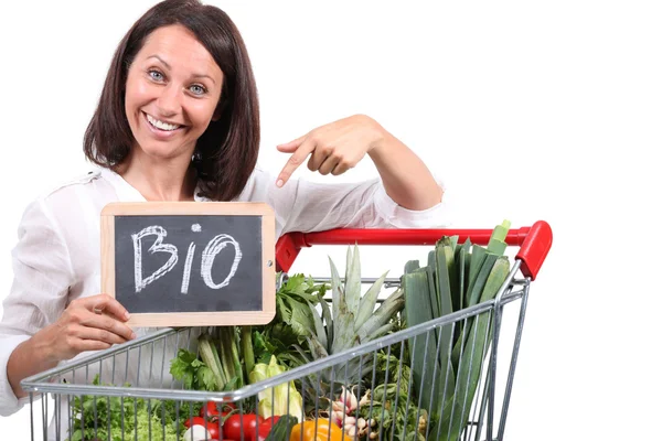Kvinna med vagn av frukt och grönsaker — Stockfoto