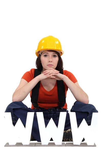 Female builder sat by letters — Stock Photo, Image