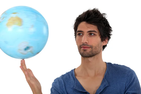Чоловік обертається глобусом — стокове фото