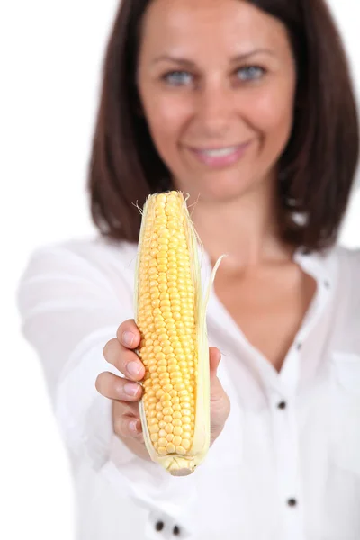 Kobieta trzyma kukurydzy Cob — Zdjęcie stockowe