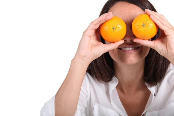Woman using oranges for eyes — Stock Photo, Image