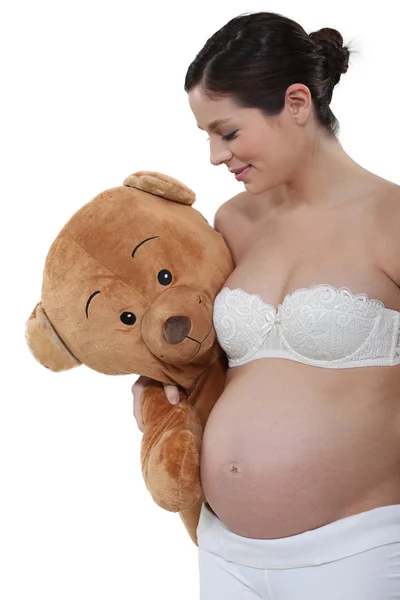 Mujer embarazada sosteniendo un oso de peluche grande —  Fotos de Stock