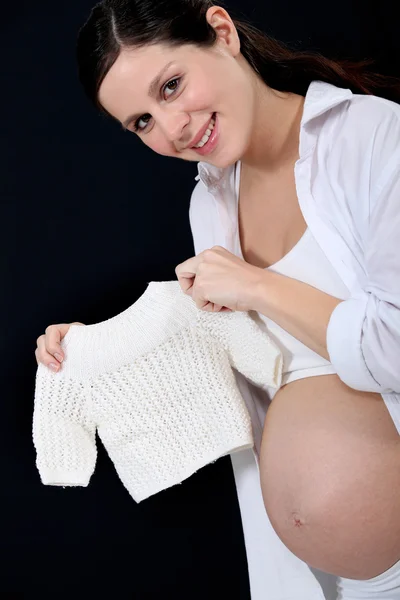 Portret van mooie zwangere vrouw houden handknit pullover — Stockfoto