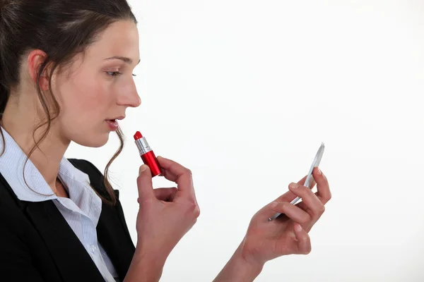 A businesswoman putting lipstick on. — Stock Photo, Image