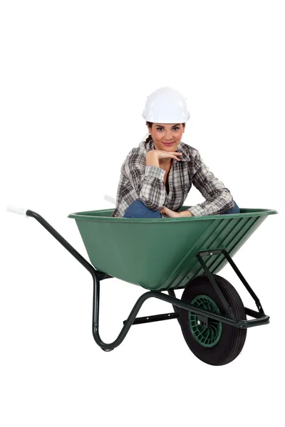 Tradeswoman sitting in a wheelbarrow — Stock Photo, Image