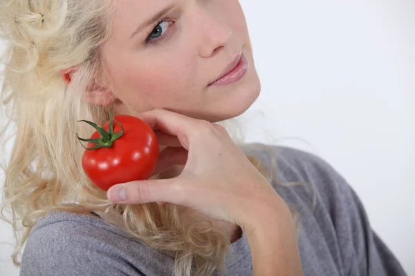 Ξανθιά γυναίκα εκμετάλλευση ντομάτα — Φωτογραφία Αρχείου