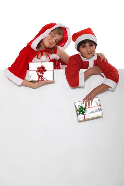 Bror och syster klädd i santa claus outfits — Stockfoto