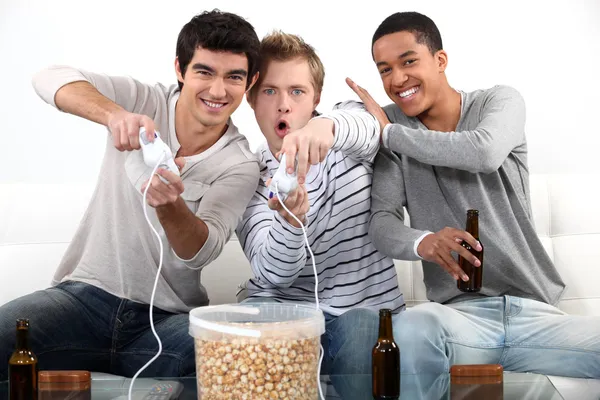 Drei männliche Teenager spielen Videospiele. — Stockfoto