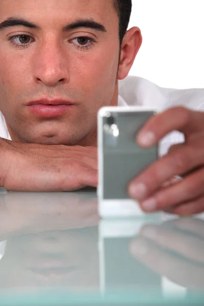 Скучный бизнесмен смотрит на мобильный телефон — стоковое фото