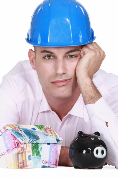 Pensive man with piggy bank — Stock Photo, Image