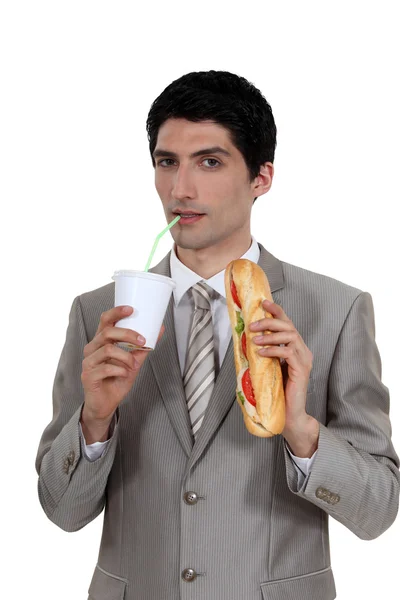 Uomo d'affari con panino e bevande — Foto Stock