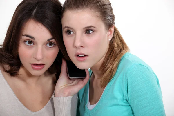 Meninas ouvindo um celular — Fotografia de Stock