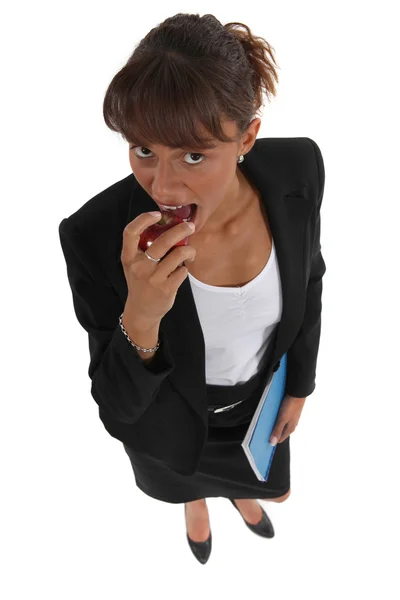 Empresária comendo maçã — Fotografia de Stock