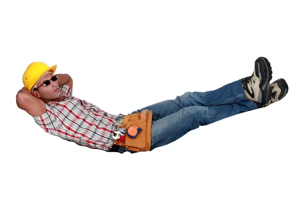 Tradesman lying in an invisible hammock — Stock Photo, Image