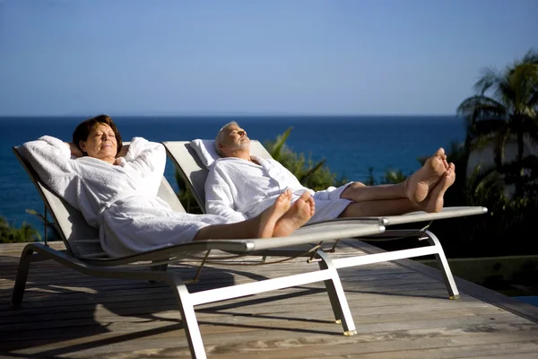 Senior couple on sun lounger whilst on holiday — Stock Photo, Image