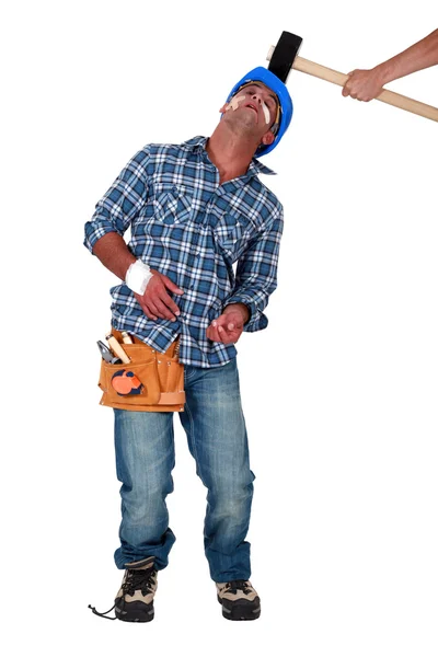 Construtor sendo atingido sobre a cabeça por martelo — Fotografia de Stock