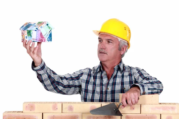 Construtor com uma casa feita de dinheiro — Fotografia de Stock