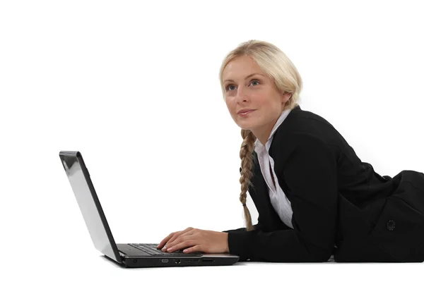 Verträumte Frau tippt auf ihrem Laptop — Stockfoto