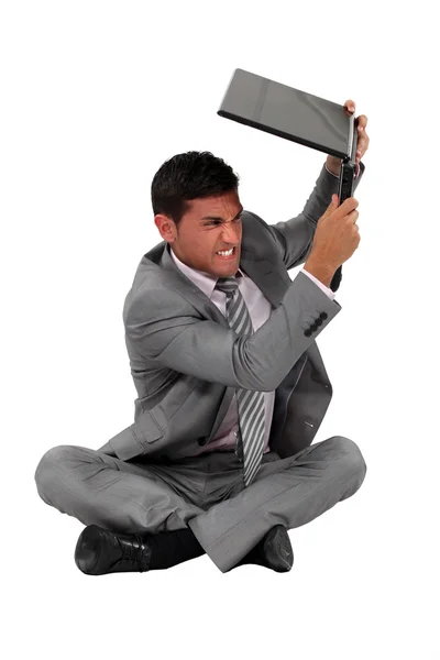Biznesmen zamierza rozbić jego laptop. — Zdjęcie stockowe