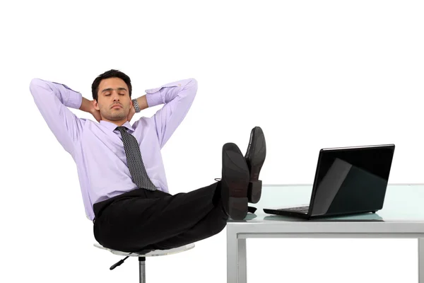 Бизнесмен расслабляется за своим столом — стоковое фото