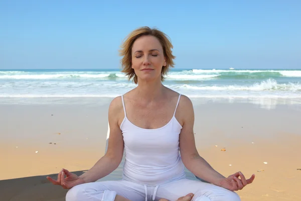 Frau meditiert am Strand — Stockfoto