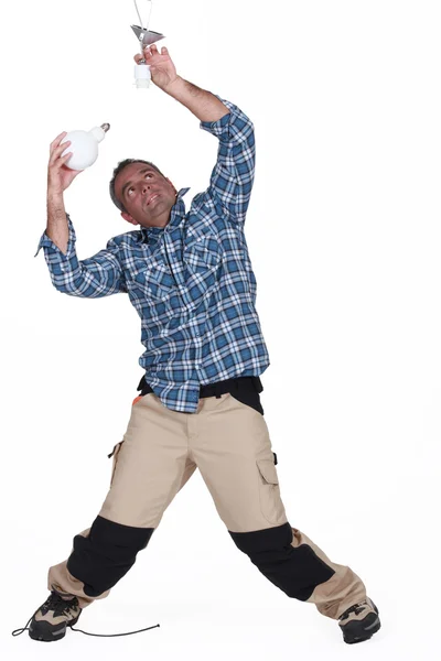 Electrician changing a light bulb — Stock Photo, Image