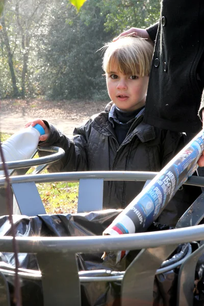 Маленький мальчик использует мусорное ведро в парке — стоковое фото