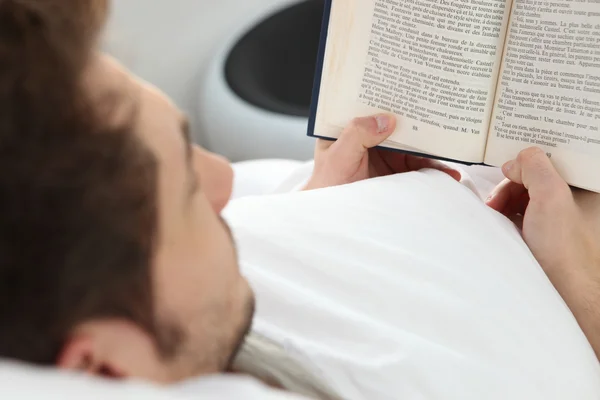 Молодой человек, читающий роман — стоковое фото