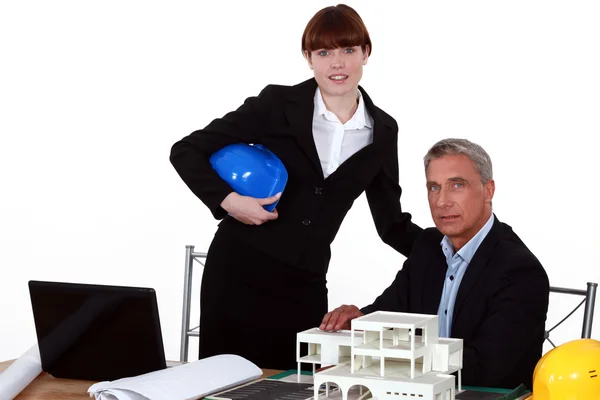 Arquitetos posando com um modelo de edifício — Fotografia de Stock