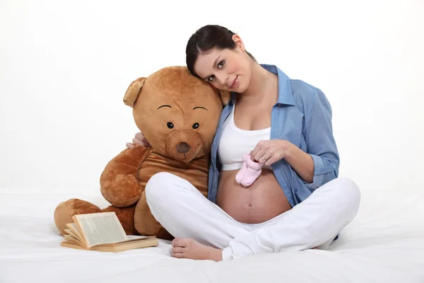 Hamile bir kadın ile bir oyuncak ayı. — Stok fotoğraf