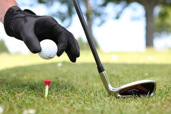 Gros plan d'un homme plaçant une balle de golf sur le tee — Photo