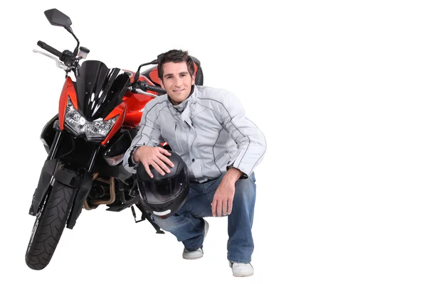 Man crouching next to motorcycle — Stock Photo, Image